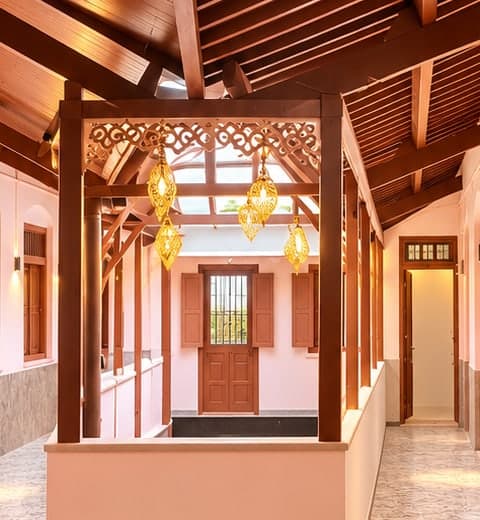 Wooden pavilion with carved fretwork and golden lanterns in the guest passage