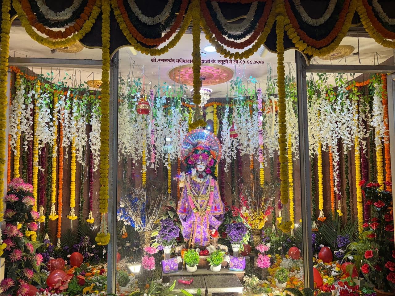 The garbhagriha of Shree Gopal Krishna Mandir decorated with marigold torans and flower strands